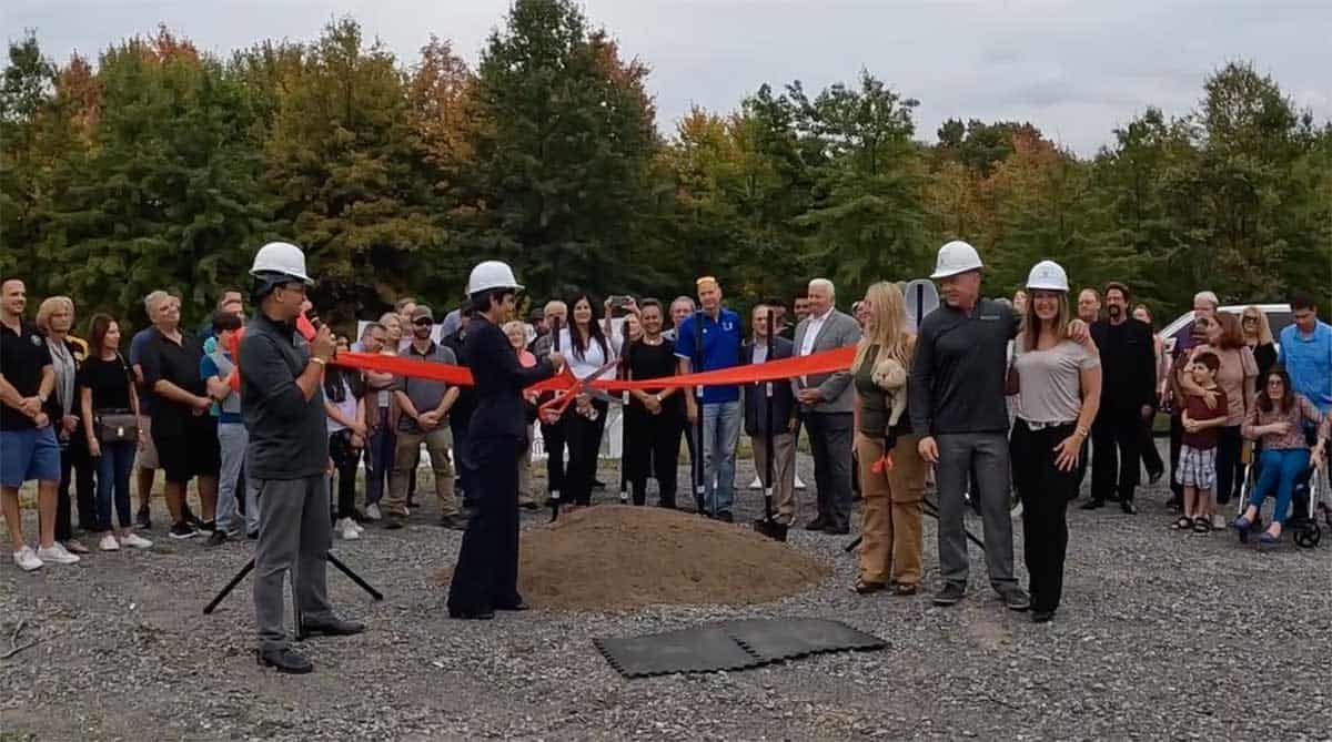 Group of people in hard hats at a ribbon-cutting ceremony for a new development