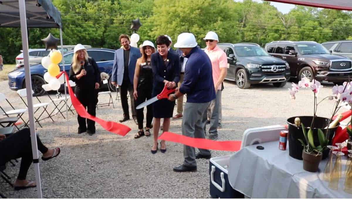 Group of people in hard hats at a ribbon-cutting ceremony for a new development