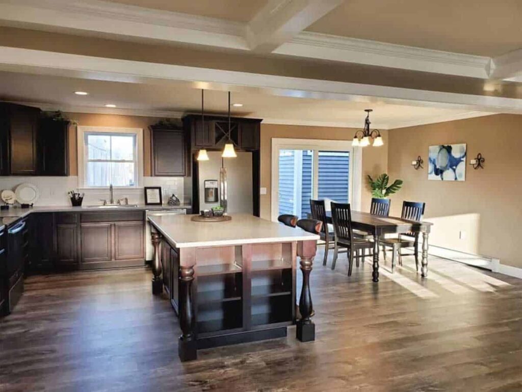 Elegant kitchen interior with dark wood cabinetry and island, spacious dining area.